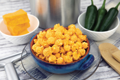 Cheddar Jalapeno Poppin Popcorn in bowl on counter with ingredients
